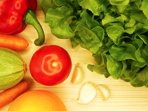 Çeşitli taze sebze ve meyvelerin ahşap arka planı. Marul, havuç, dolma biber, kabak, domates, sarımsak, elma, armut, muz..