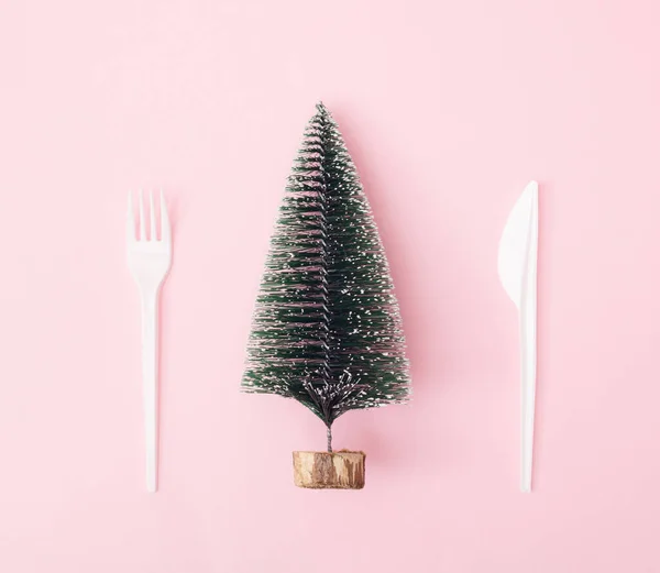 圣诞树和新年树雪白的塑料刀和叉子粉红的背景 最小的设计 复制空间 — 图库照片
