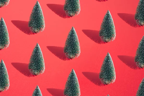 Kırmızı Pastel Arka Planda Yeşil Karlı Noel Ağacı Desen — Stok fotoğraf