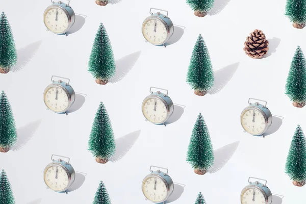 布置好的绿色新年圣诞树和银制复古手表 午夜12点手持 白色粉刷背景上的褐色圆锥 — 图库照片
