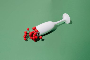 Yeşil yılbaşı arka planında Çin kirazlı beyaz şampanya kadehi..