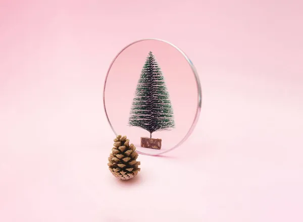 松果在镜子里看到了新年的绿色雪树 粉红的背景 最小假日设计和概念 — 图库照片