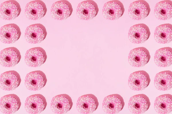 Rózsaszín Gyűrűs Fánkok Mázzal Fehér Morzsákkal Rózsaszín Pasztell Háttérrel Minta — Stock Fotó