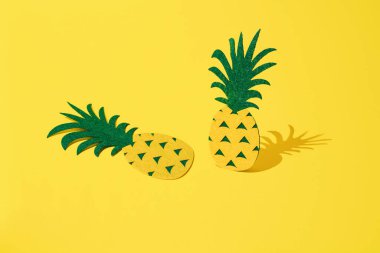 Sarı arka planda iki ananas.
