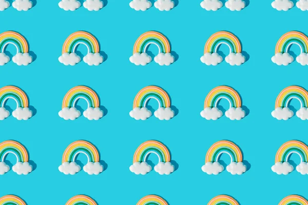 Small colorful rainbow cookie with clouds. Pattern. Blue background.
