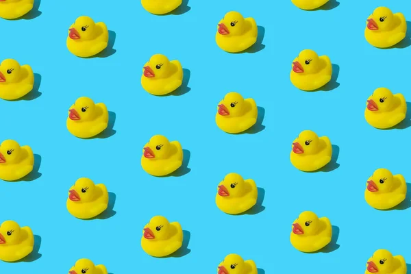 Yellow rubber toy duck on a blue background. Pattern.