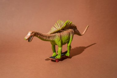 Kaykaydaki dikenli dinozor. Kahverengi arka plan. Şablon. En düşük tasarım.