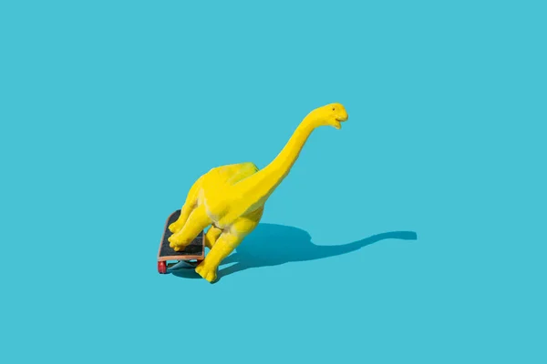 Műanyag Játék Dinoszaurusz Lovagló Gördeszka Kék Háttér Minimális Tervezés — Stock Fotó