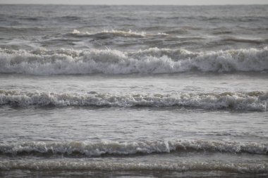 Öğleden sonra deniz dalgaları ve gökyüzünün resmi