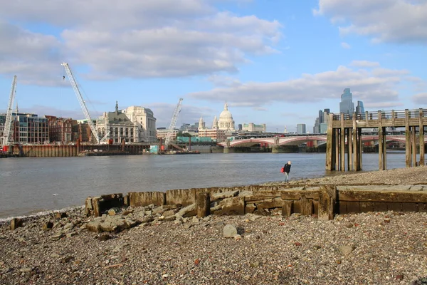 Londra, İngiltere - 3 Eylül 2021: Stony mud larkers 'dan peyzaj şehri manzarası Thames Nehri' nin güney kıyısında, Globe yakınlarındaki gökdelenleri ve Tate 'in St. Paul katedrali arka planı ve rıhtımdaki ahşap tekne limanlarına sahip. 
