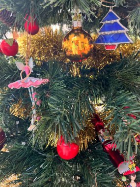 Noel ağacı süslemelerini altın kırmızı cam mücevherler ve geleneksel tahta oyuncaklar ile kapat. Periler ve simler yeşil köknar dallarına asıldı. İç kısımlarında kostüm vitray gün ışığı vardı.