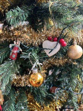 Noel ağacı süslemelerini altın kırmızı cam mücevherler ve geleneksel tahta oyuncaklar ile kapat. Periler ve simler yeşil köknar dallarına asıldı. İç kısımlarında kostüm vitray gün ışığı vardı.