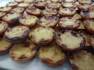 Pastel de nata hamur işlerini kapatın. Taze lezzetli, lezzetli, sıcak kremalı pastalar Lizbon Portekiz Avrupa 'daki Time Out gıda pazarında gurme pastanesinde satışa sunuldu.
