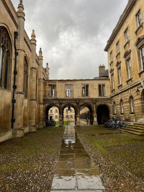 Cambridge, Doğu Anglia / İngiltere - 22 Şubat 2022: Peterhouse College Cambridge Üniversitesi gri gökyüzü ile yağmurlu bir günde kemer ve giriş koridorlu tarihi bina