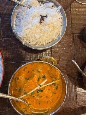 Lezzetli Hint baharatlarıyla birlikte köri tabağını kapat metal otantik kase içinde pirinç ve sebzelerle birlikte akşam yemeğinin bir parçası restoranın iç kısımlarında kuş bakışı yatıyordu.