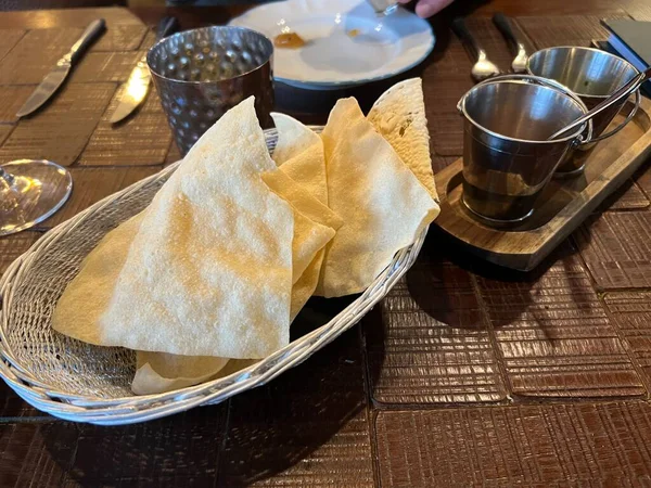 Hint restoranının ahşap masasından taze ve çıtır çıtır patlamış patatesleri kapatıyoruz. Başlangıç yemeği olarak lezzetli baharatlar ve sıcak soslar.