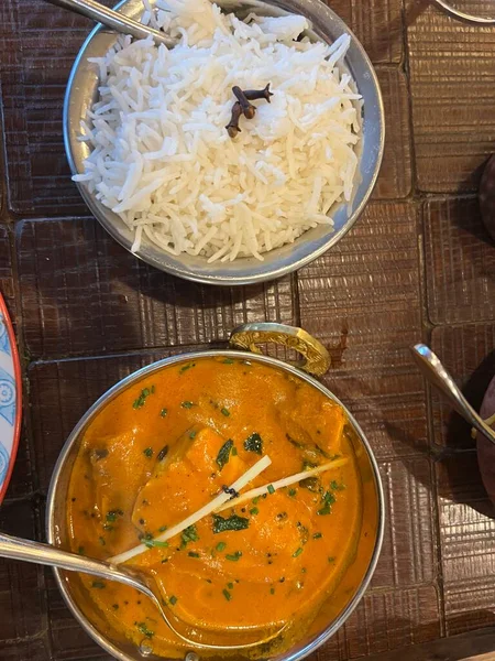 Lezzetli Hint baharatlarıyla birlikte köri tabağını kapat metal otantik kase içinde pirinç ve sebzelerle birlikte akşam yemeğinin bir parçası restoranın iç kısımlarında kuş bakışı yatıyordu.