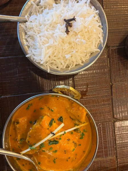 Lezzetli Hint baharatlarıyla birlikte köri tabağını kapat metal otantik kase içinde pirinç ve sebzelerle birlikte akşam yemeğinin bir parçası restoranın iç kısımlarında kuş bakışı yatıyordu.
