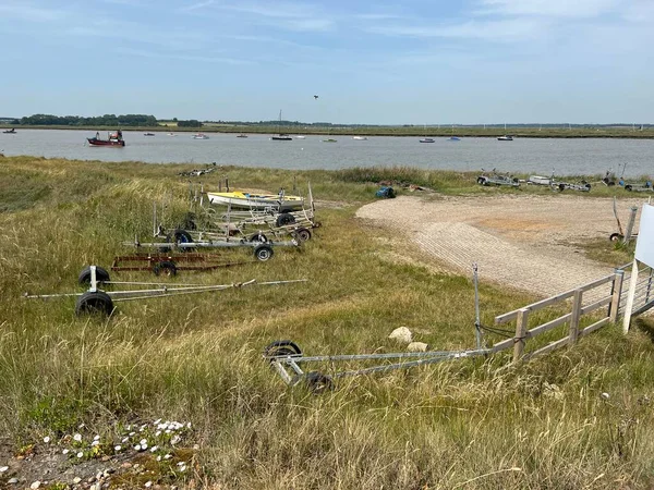 Suffolk, Suffolk, Doğu Anglia 'daki Aldeburgh sahilinin güzel manzarası Martello savaş kulesi tarafından kumsalın kumlu sahili üzerinde yaz başında mavi gökyüzü ile