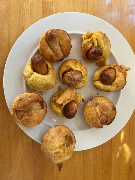 Close up of mini Yorkshire pudding with vegan sausages, these individual hand made Toad in the Hole snacks served on white plate flat lay view for breakfast lunch or dinner