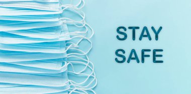 Pandemic  personal protective equipment, text STAY SAFE.  COVID-19 SARS-COV-2 Blue banner background. Copy space.