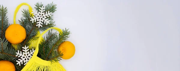 Noel ağacı dallı sarı eko ip alışveriş poşetinde üç anahtar ve kopyalama alanı olan beyaz arka planda kar taneleri. Noel yatağı. Noel alışveriş konsepti.