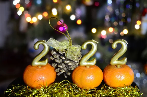 2022 numaralı altın rengi, koyu arka planda altın renkli koni ve yeni yıl şapkası. Noel kavramı, yeni yıl.