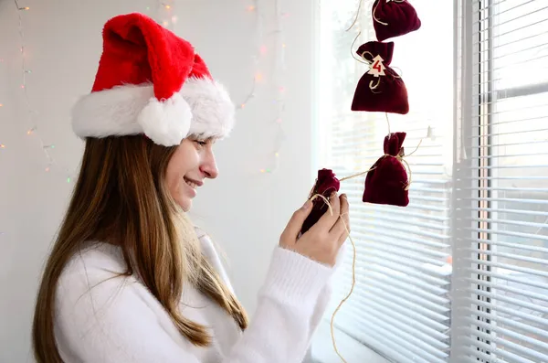 Çocuk kız, elinde sürpriz takvimi olan küçük hediye paketlerini açıyor. Mutlu noeller ve yeni yıl.