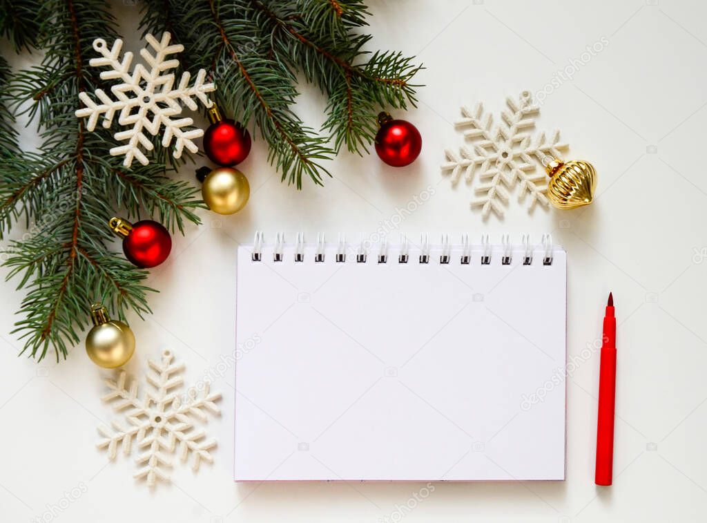 New Year goal list 2022. notebook for writing about plan listing of new year goals and resolutions setting on white background with Christmas tree and red glitter balls and snowflakes . Wish list.