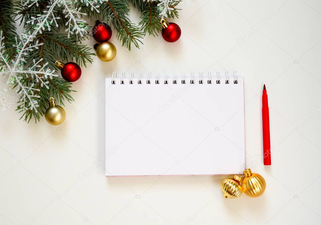 New Year goal list 2022. notebook for writing about plan listing of new year goals and resolutions setting on white background with Christmas tree and red glitter balls and snowflakes . Wish list.