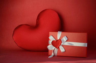 Kırmızı hediye kutusu, beyaz yay ve kırmızı arka planda kalpler. Sevgililer Günü hediyesi, 8 Mart, Anneler Günü, doğum günü.