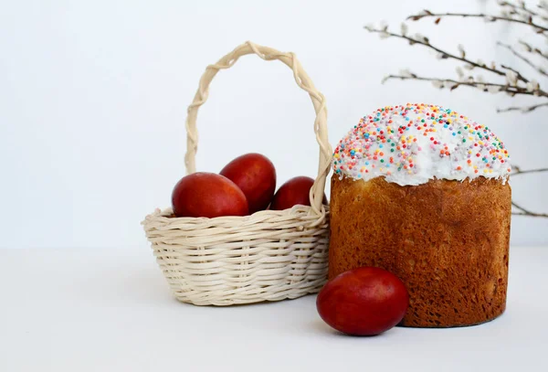 Paskalya pastası, sepete boyanmış yumurtalar, beyaz arka planda söğüt dalları, fotokopi alanı..