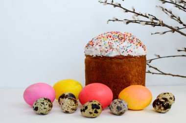 Paskalya pastası, boyanmış yumurtalar, beyaz arka planda söğüt dalları ve kopya alanı.