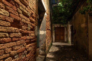Cannaregio Bölgesi 'nde dar bir sokakta eski tuğla duvar, Venedik, İtalya