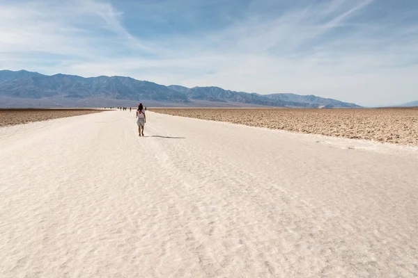 A lonely person hiking through famous Badwater Basin in the Death Valley, USA