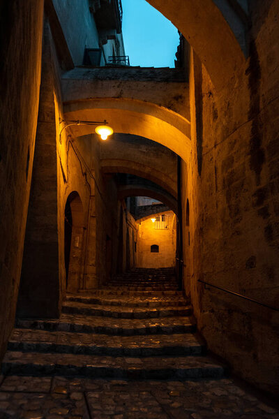 An empty alley with arches above, historic downtown of Matera, Southern Italy
