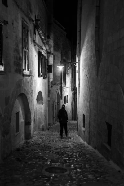 A person walking through a narrow alley at night, Southern Italy