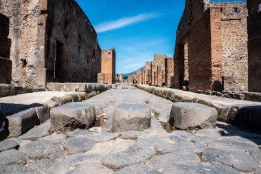 POMPEII, ITALY - MAY 04, 2022 - A crosswalk of a typical Roman road in the ancient city of Pompeii, Southern Italy