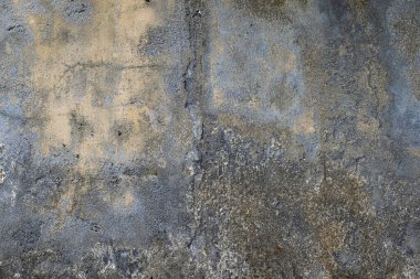Küf ve dökülen kirli dokusu olan gri ve sarı beton bir duvar.