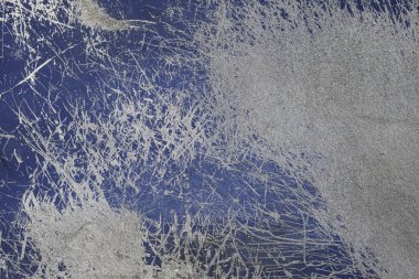 Üzerinde çizikler ve çatlaklar olan mavi beton duvar.
