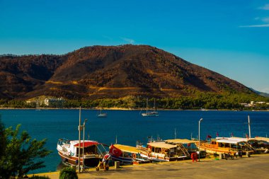 ICMELER, TURKEY: Türkiye 'de Marmaris yakınlarında güneşli bir yaz gününde Icmeler' de kıyı manzarası ve gemilerle manzara.