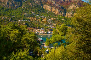 Türkiye 'nin Marmaris yakınlarındaki Mugla ilinde güneşli bir yaz gününde Turunc köyünün dağ ve deniz manzarası.
