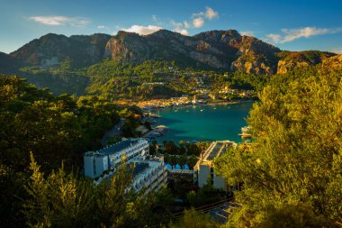 Türkiye 'nin Marmaris yakınlarındaki Mugla ilinde güneşli bir yaz gününde, Turunc köyündeki plajın ve 5 yıldızlı otelin en iyi manzarası.