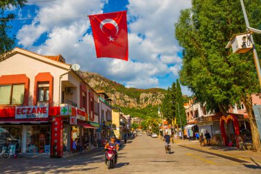 Türkiye 'nin Marmaris yakınlarındaki Mugla ilinde güneşli bir yaz gününde Turunç' un merkezinde geleneksel turizm caddesi.