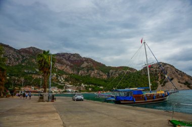 Türkiye 'nin Marmaris ilçesi Mugla ilçesi yakınlarındaki bulutlu bir havada Turunch' ta rıhtımdaki teknelerin manzaralı manzarası.