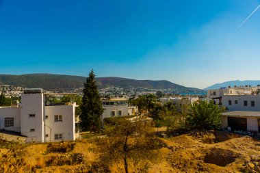 Güneşli bir günde Bodrum şehrindeki beyaz evlerin, denizin ve dağların en iyi manzarası..