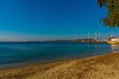 Güneşli bir günde Bodrum 'da gemi ve dağ manzaralı güzel bir deniz manzarası var.