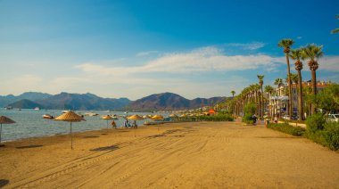 Türkiye 'nin Marmaris kentindeki kumsalda güneşli bir günde Akdeniz ve dağların manzarası.