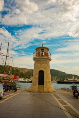 Marmaris, MUGLA, TURKEY: bulutlu bir günde gemi ve yatların rıhtımında deniz feneri manzarası.