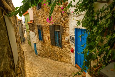 Marmaris, MUGLA, TURKEY: eski evler ile süslenmiş cadde Marmaris tarihi merkezi. Beyaz tuğlalı, yeşil bitkili ve çiçekli evlerin arasında merdivenleri olan dar sokaklar.